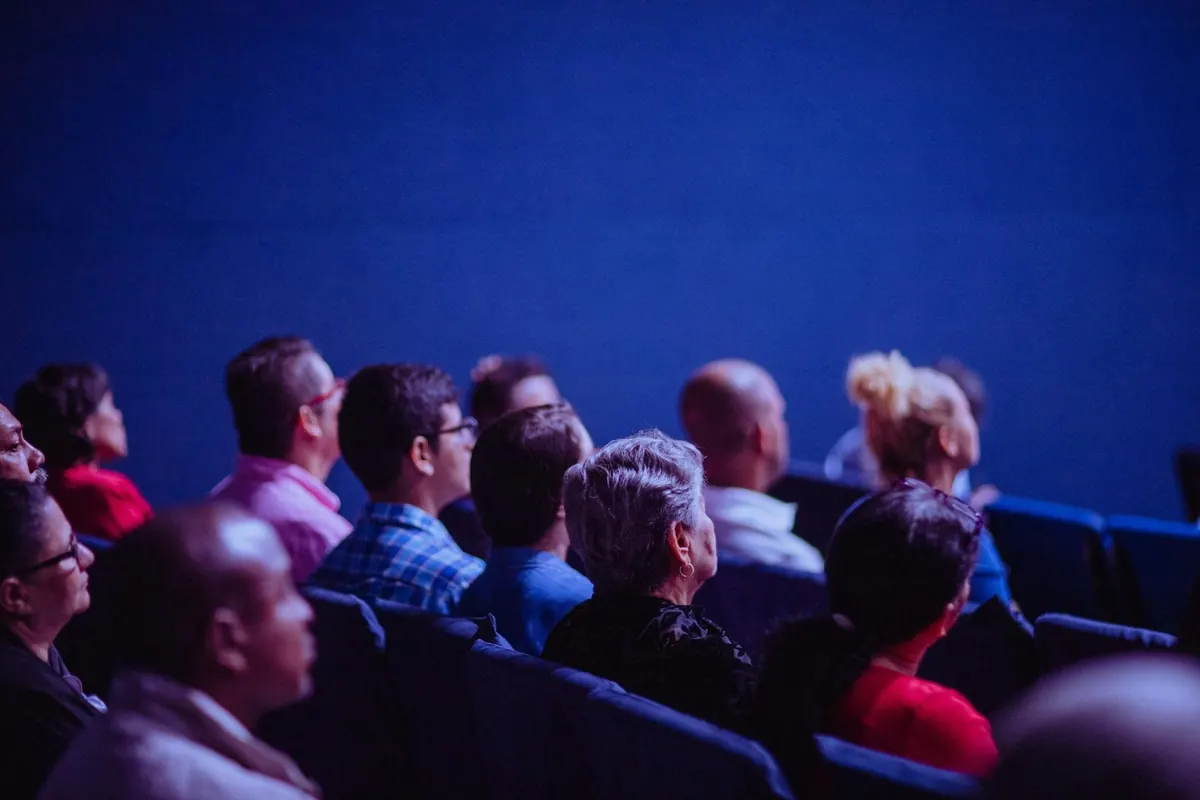 Conference audience under blue stage lighting